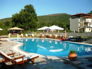 a swimming pool with chairs and umbrellas at a resort at Villa Riviera in Stavros