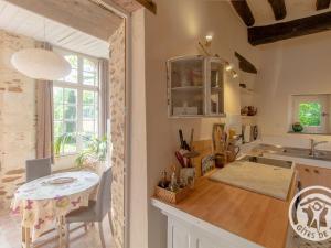 a kitchen with a table and a counter top at Charmant gîte familial avec parc, près des vignobles, à 30 min d’Angers - Confort et cadre raffiné. - FR-1-622-34 in Rochefort-sur-Loire