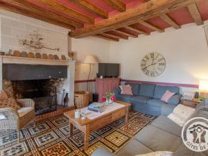 un soggiorno con un divano blu e un camino di Charmant gîte familial avec parc, près des vignobles, à 30 min d’Angers - Confort et cadre raffiné. - FR-1-622-34 a Rochefort-sur-Loire