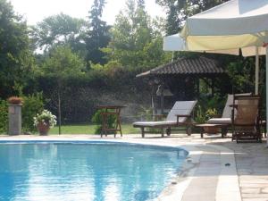 a swimming pool with two chairs and an umbrella at Villa Riviera in Stavros
