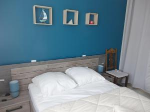 - une chambre dotée d'un lit avec un mur bleu dans l'établissement Maison Sarzeau, 4 pièces, 6 personnes - FR-1-639-53, à Sarzeau