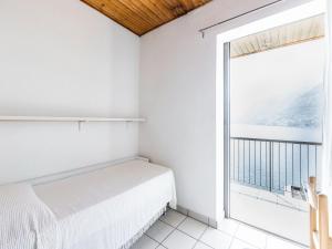 Pognana LarioにあるScenic apartment in Pognana Lario with large terraceの白いベッドルーム(ベッド1台、大きな窓付)