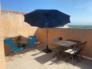 Tressan的住宿－Le Clos Bellevue，庭院内桌椅和遮阳伞
