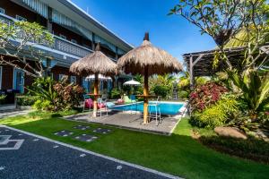 a resort with a pool and tables and umbrellas at D-Anyar Stay and Surf Canggu in Canggu