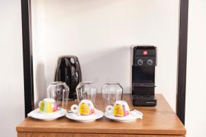 una mesa de madera con tazas y vasos. en Centrally Elegant Suite by Acropolis en Athens