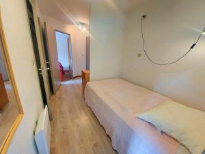 a bedroom with two beds in a room with a hallway at Cosy appartement au centre de Morillon, proche télécabine, balcon et parking - FR-1-624-104 in Morillon