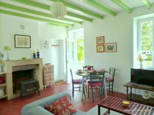 a living room with a table and a fireplace at Longère XVIIIe rénovée avec jardin, proche forêt et loisirs, animaux bienvenus - FR-1-489-376 in Lurcy-Lévis