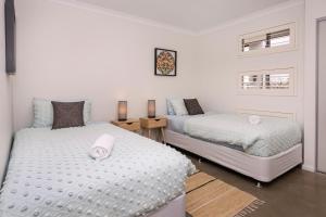 2 camas en un dormitorio con paredes blancas en Roanoke Retreat, en Dunsborough