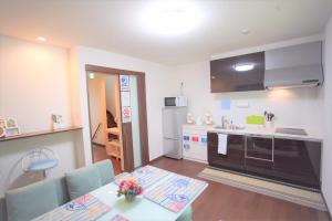 a kitchen and dining room with a table and chairs at Kaika Inn in Osaka
