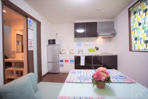 a kitchen with a table with a vase of flowers on it at Kaika Inn in Osaka +25 photos