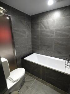 a bathroom with a bath tub and a toilet at Grace Hotel in Taipei
