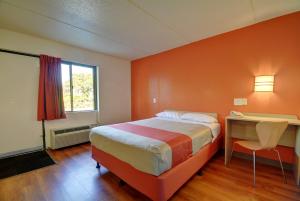 a bedroom with a bed and a desk and a window at Motel 6-Chicopee, MA - Springfield in Chicopee +43 photos