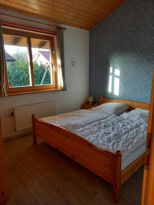 a bedroom with a wooden bed with a window at Anne See Ferienhaus Sehestedt in Sehestedt