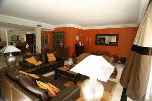 a living room with leather furniture and orange walls at Hotel Soltroia - Foz Do Sado in Troia