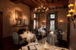 a woman standing in a dining room with tables at Van der Valk Hotel Kasteel Terworm in Heerlen +39 photos