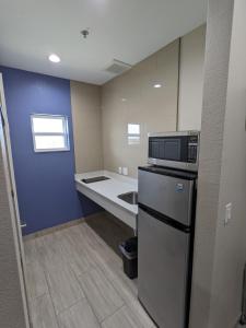 a small kitchen with a refrigerator and a sink at Holiday Inn motel in Aransas Pass