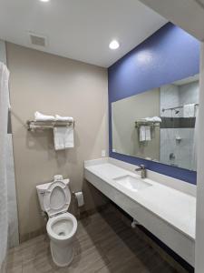 a bathroom with a toilet and a sink and a mirror at Holiday Inn motel in Aransas Pass
