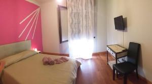 una camera con letto, sedia e televisore di appartamento quadrifoglio a Desenzano del Garda
