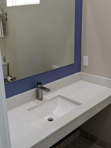 y baño con lavabo y espejo grande. en Holiday Inn motel en Aransas Pass