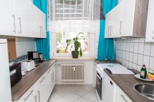 a kitchen with white cabinets and a window at Othman Appartements Falkenstraße 26 3OG L in Hannover