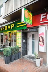 a store on a street with plants in front of it at Othman Appartements Falkenstraße 26 3OG L in Hannover