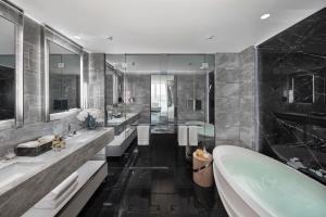 a bathroom with three sinks and a bath tub at Crown Towers Sydney in Sydney