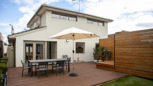 a patio with a table and chairs and an umbrella at Brighton House in Melbourne
