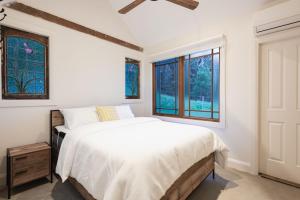 um quarto com uma cama e duas janelas em Yarrawong Farm, near Berry em Jaspers Brush
