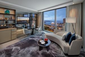 a living room with a couch and a large window at Crown Towers Sydney in Sydney