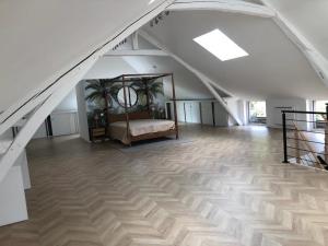 a attic room with a bed in the middle at Gîte dans un Haras in Émanville