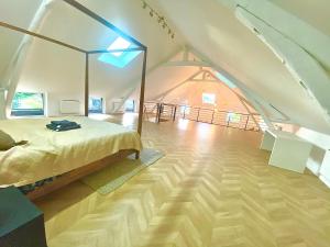 a bedroom with a bed and an attic at Gîte dans un Haras in Émanville