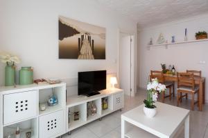 a living room with a tv on a white entertainment center at Apt 200 meters from the beach id in Blanes