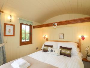 Un dormitorio con una gran cama blanca y una ventana en Llety'r Bugail 2, en Caernarfon