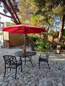 a table and two chairs with a red umbrella at Casa Ejutla de Crespo, Oaxaca 