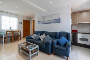 聖安東尼奧·德·卡隆的住宿－Apartament Sant Antoni de Calonge，客厅配有蓝色的沙发和桌子