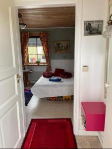 um pequeno quarto com uma cama e uma janela em Cosy non smoking Cabin close to beach,Alnö em Sundsvall