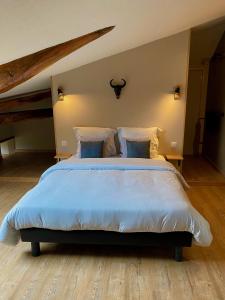 1 dormitorio con 1 cama grande con sábanas y almohadas azules en Le Petit Bleu Chambre d'hôtes, en Bourg-de-Visa