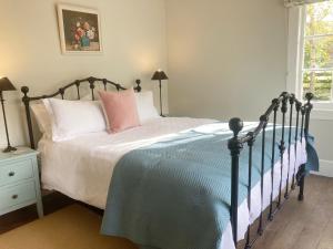 Country Bliss Cottage في غريتاون: غرفة نوم بسرير وردي وملاءات زرقاء