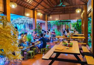 a group of people sitting at tables in a restaurant at Trang An Village Homestay in Ninh Binh