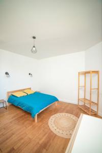 1 dormitorio con 1 cama azul y suelo de madera en Le petit cocon de la butte, en Gourdon-en-quercy