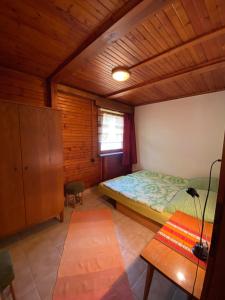 Pelso Vendégház في بالاتونماريافوردو: غرفة نوم بسرير وسقف خشبي