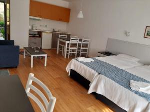 a bedroom with a bed and a table and a kitchen at Hylatio Tourist Village in Pissouri