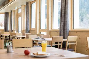 a dining room with tables and chairs and windows at Hotel Tia Smart Natur in Kaunertal