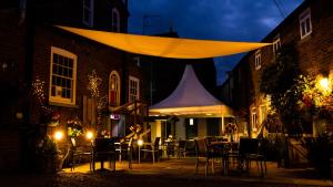 a tent is set up on a patio at night at The Mansion House Hotel in Holbeach