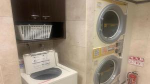 a bathroom with a washing machine and a washer at Toyoko Inn Osaka Namba Nippombashi in Osaka