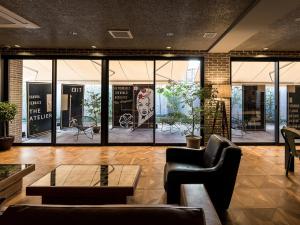vestíbulo con sillas, mesa y ventanas en Sakura Terrace The Atelier, en Kioto