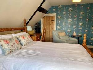 a bedroom with a bed and a chair at The Mansion House Hotel in Holbeach