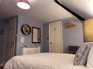 a bedroom with a white bed and a mirror at The Mansion House Hotel in Holbeach