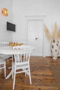 een witte eetkamer met een witte tafel en stoelen bij Mykonos be Chic Luxury Mansion in Mykonos-stad