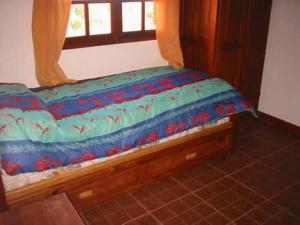 1 cama con edredón azul y ventana en Cabañas Oma Lissi, en Merlo 13 fotos más